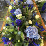 Hydrangea and Delphinium coffin spray by Creative Floral Designs